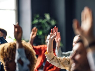 Students raising hands in class